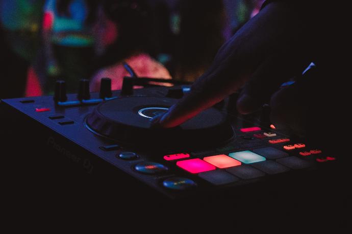 person playing dj controller in a dark room